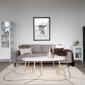 Modern living room with gray sofa, coffee table, and decorative items.